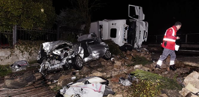 Estado en el que ha quedado el vehículo que ha colisionado esta noche con un camión (al fondo) en el termino municipal de Sorauren, en Pamplona, donde tres personas han sido sacadas del coche por los bomberos.