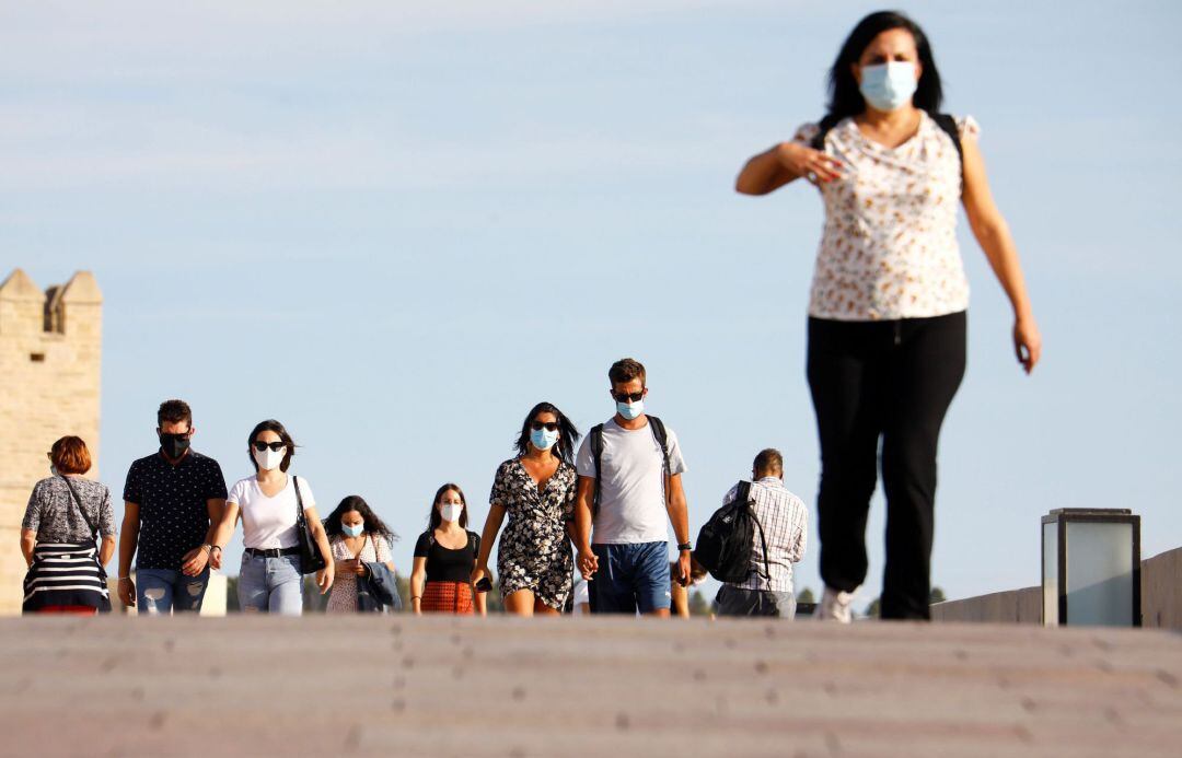 Varias personas caminan por las calles del casco histórico de Córdoba protegidas con mascarillas