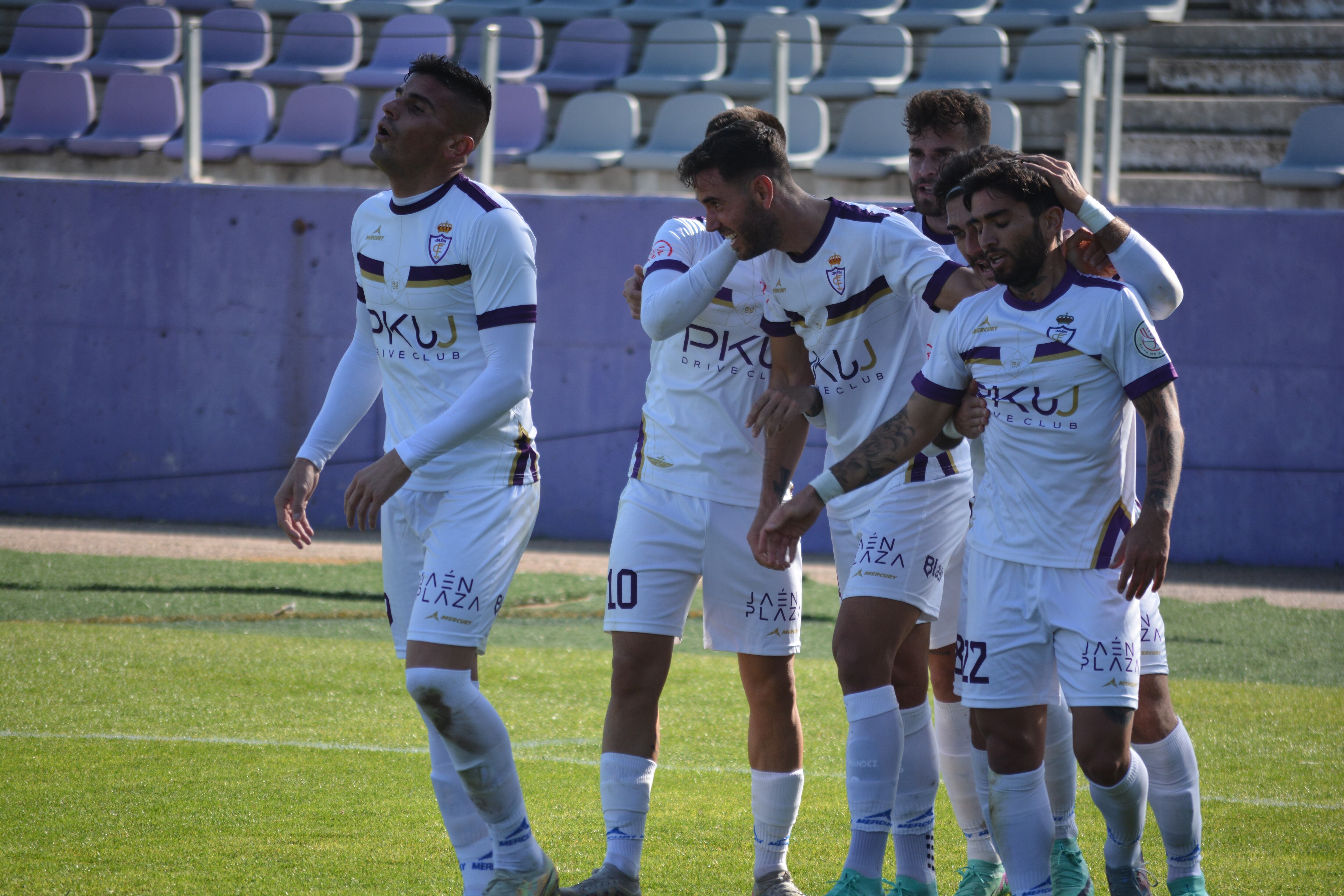 Los jugadores del Real Jaén abrazan a Carlos Fernández, autor de dos goles este domingo.