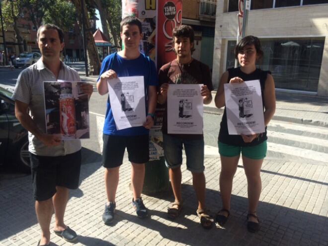 El portaveu de la CUP, David Vidal, amb els tres militants d&#039;Arran, Martí Llaurador, Joan Juncosa i Roser Palomar a la cartellera de la cantonada de la Riera Miró i el carrer Raseta de Sales.