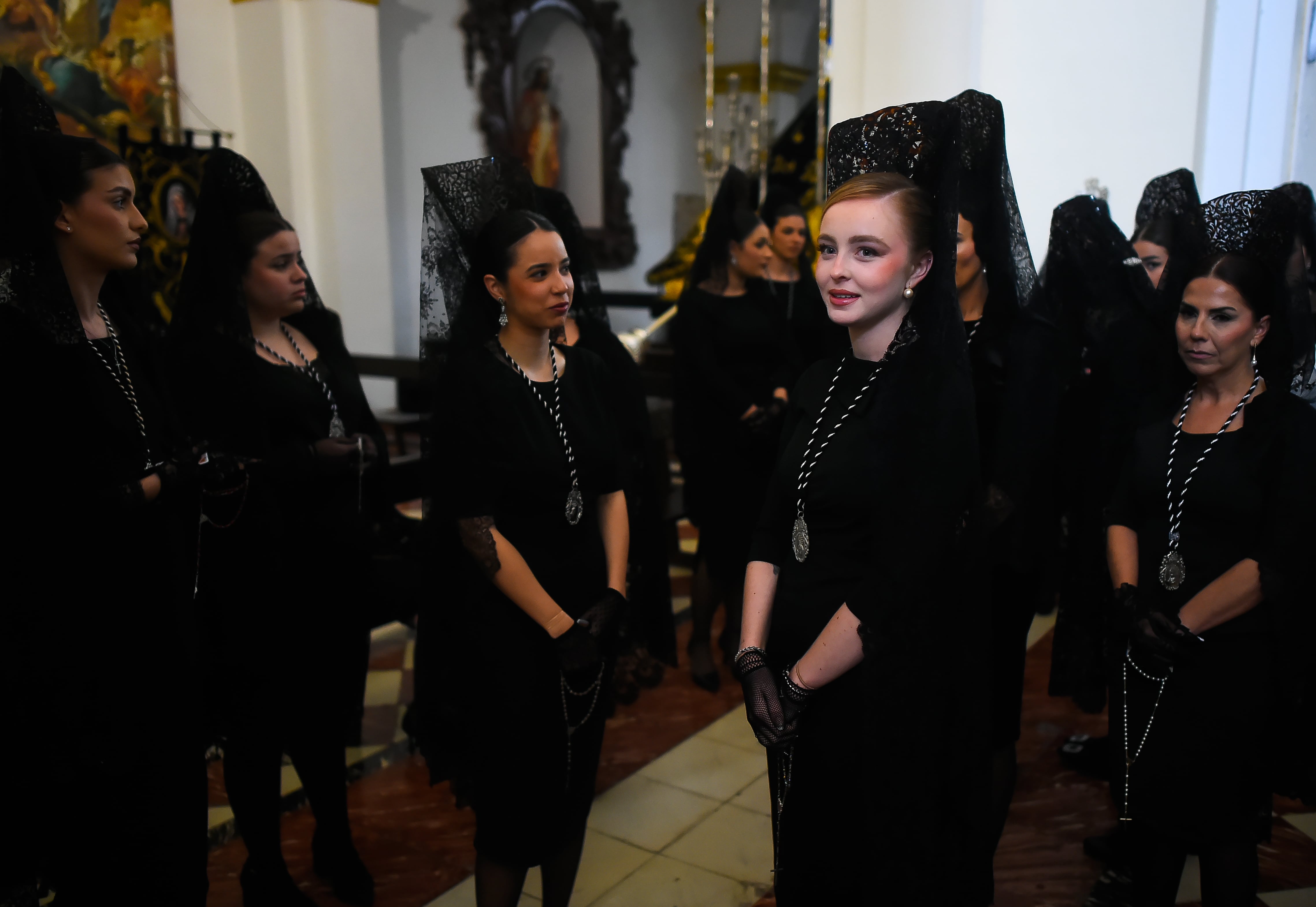 MALAGA, SPAIN - 2026/03/31: Women wearing traditional "mantilla" (mourning clothes) from 'Humillacion y estrella' brotherhood, are seen waiting inside the church as they take part in a procession on Holy Tuesday to mark the Holy Week celebrations. Thousands of worshippers wait to see the processions with the statues of Christ and the Virgin Mary as part of the traditional Holy Week celebrations. In Andalusia, Easter brings together thousands of people from all over the world and it's considered one of the most important religious and cultural events of the year. (Photo by Jesus Merida/SOPA Images/LightRocket via Getty Images)