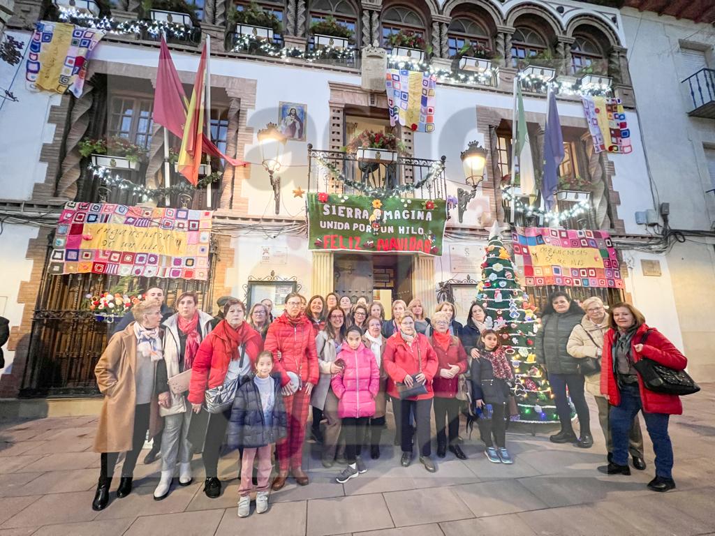 Foto de familia con las mujeres participantes ante los trabajos expuestos en la fachada del Ayuntamiento de Jódar