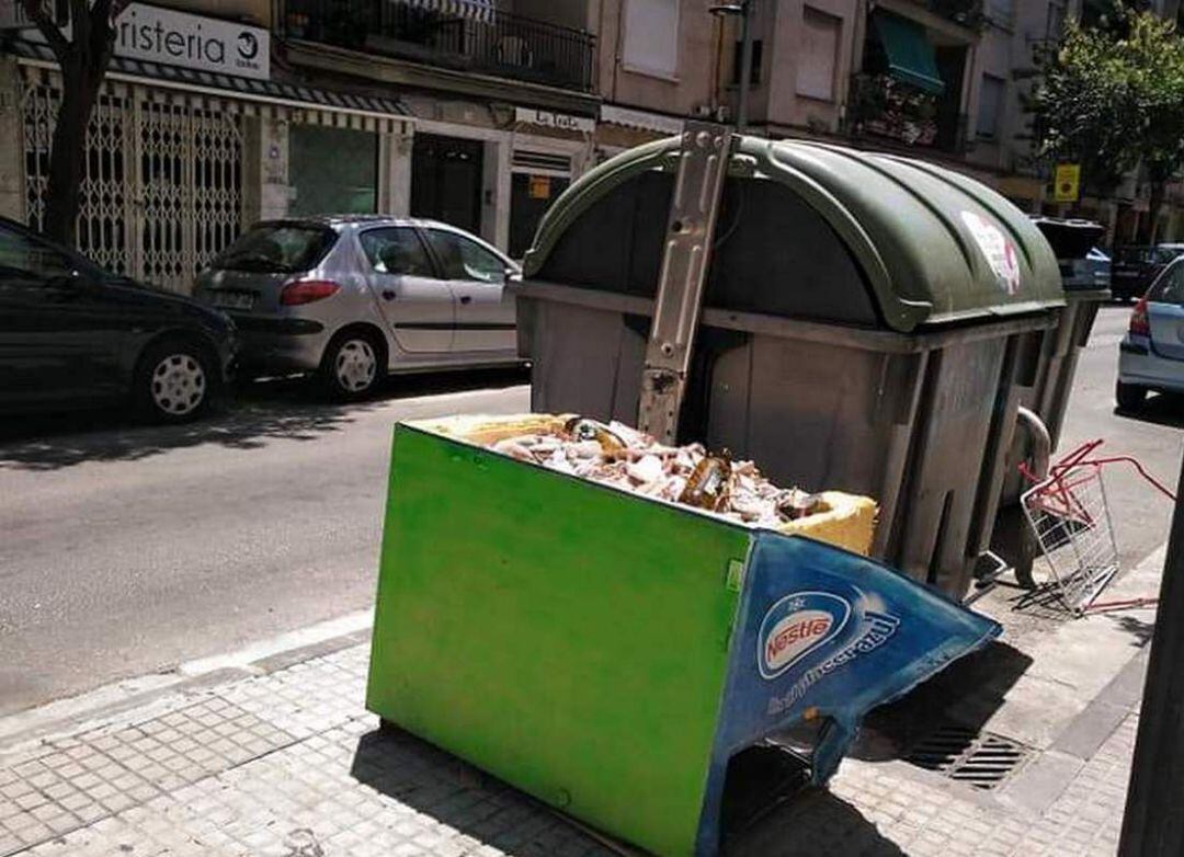 Escombros de obras junto a un contenedor en Gandia. 