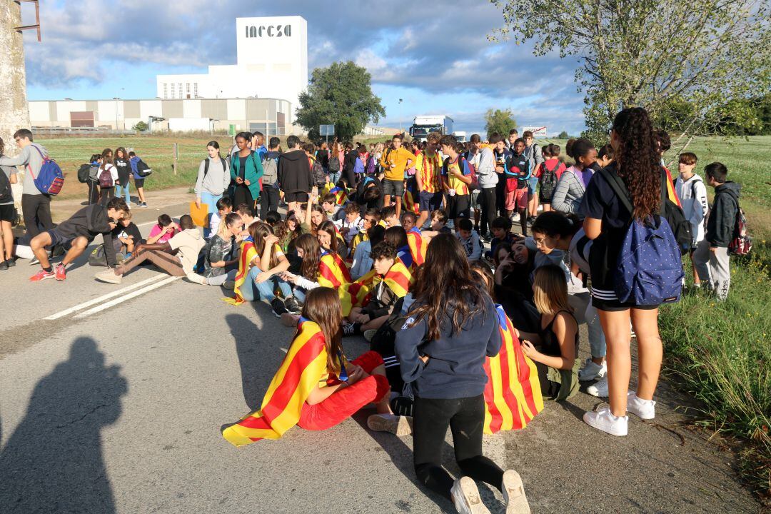 Els estudiants de l'institut de Cassà de la Selva asseguts enmig de la calçada