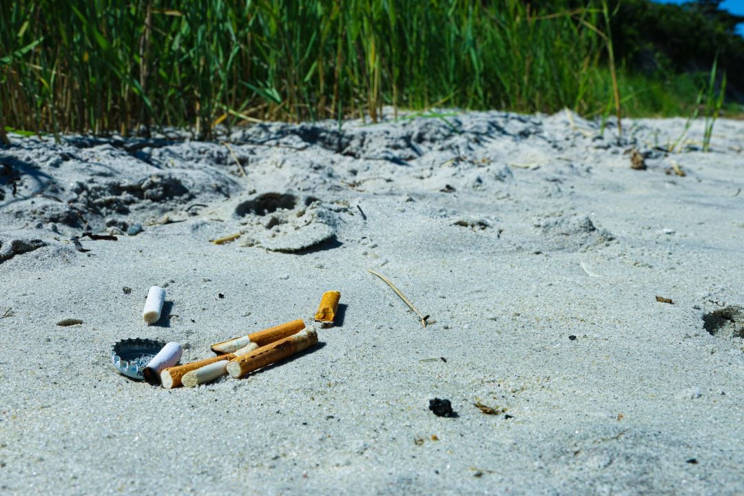 Colillas en una playa. Imagen de archivo