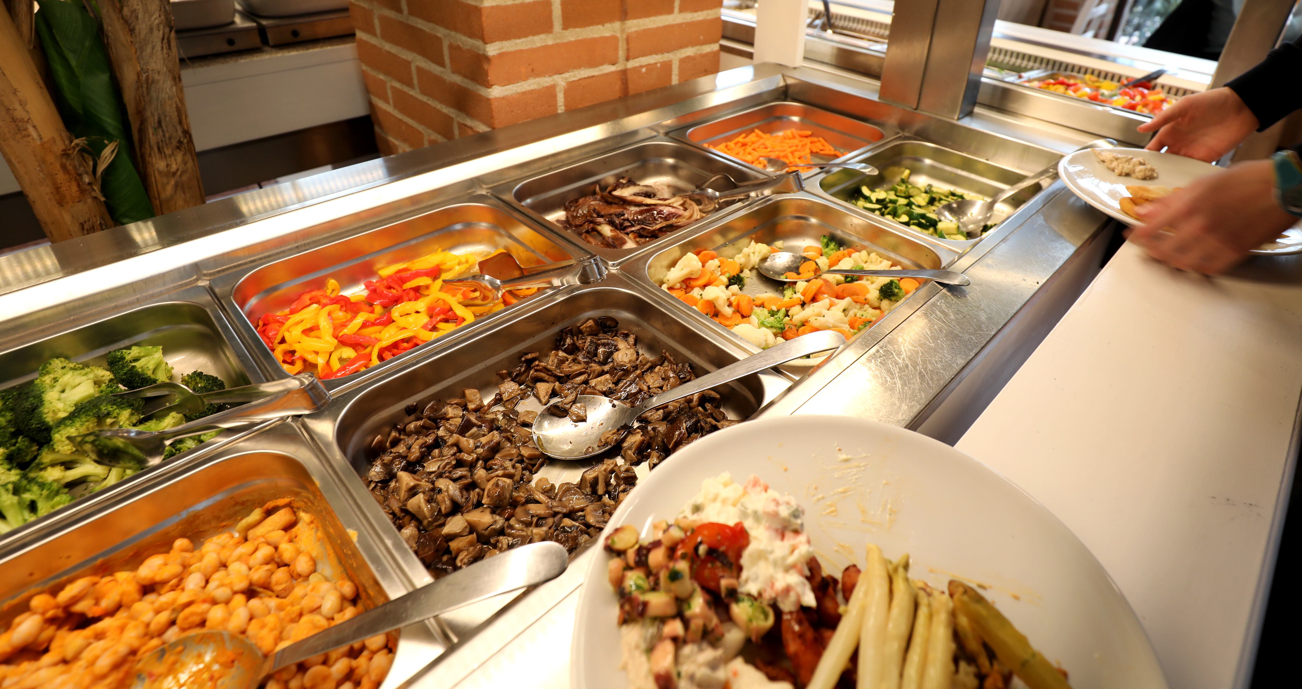 Inside a self service restaurant with many raw and cooked foods