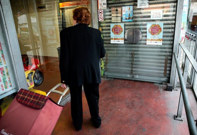 Una mujer ante las puertas del Mercado de Sant Antoni, cerrado por la huelga general del 3 de octubre en Cataluña