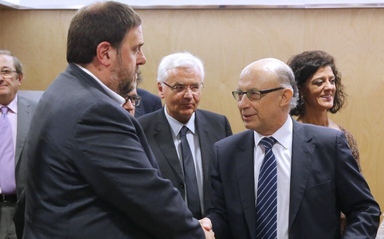 El ministro de Hacienda y Administraciones Públicas en funciones, Cristóbal Montoro, saluda al vicepresidente catalán y conseller de Economía, Oriol Junqueras. 