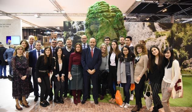 El vicepresidente primero del Gobierno de Castilla-La Mancha posa, junto a otras autoridades y visitantes, al lado de la recreación del Nacimiento del río Cuervo en el stand de Castilla-La Mancha en Fitur.