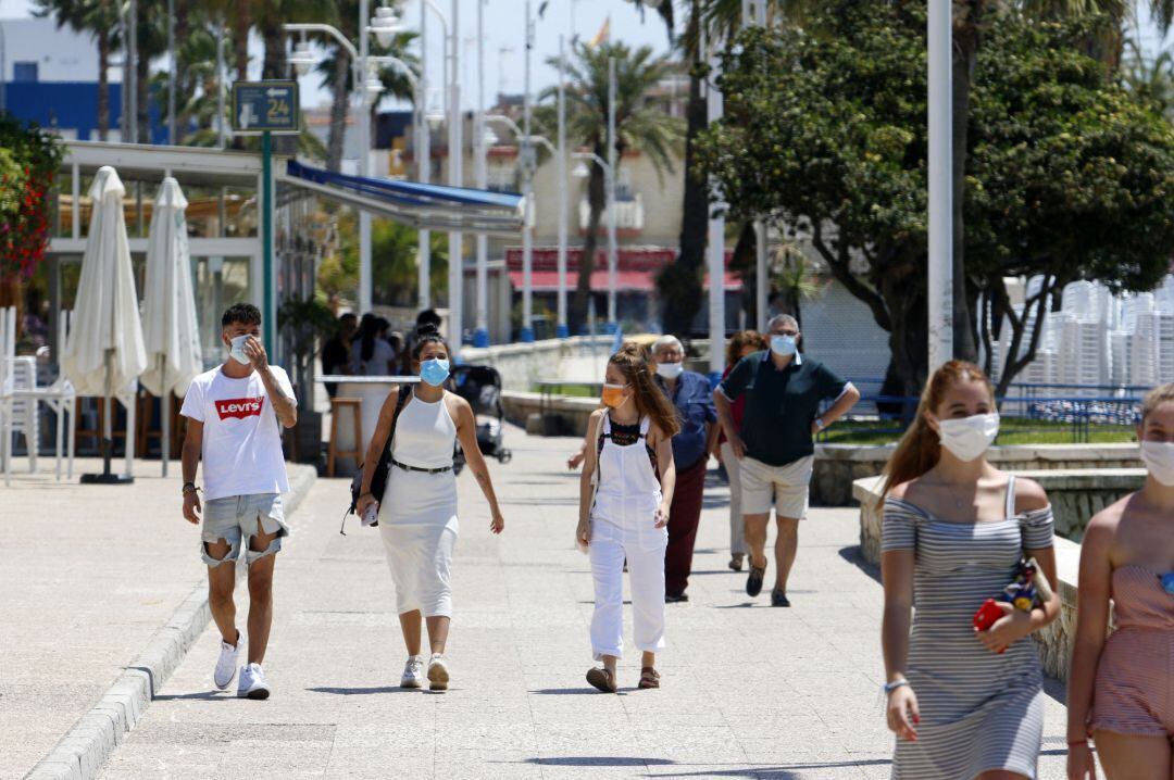 Un grupo de personas pasean por el paseo marítimo de Pedregalejo  durante la Fase 1 en Málaga a 20 de mayo del 2020