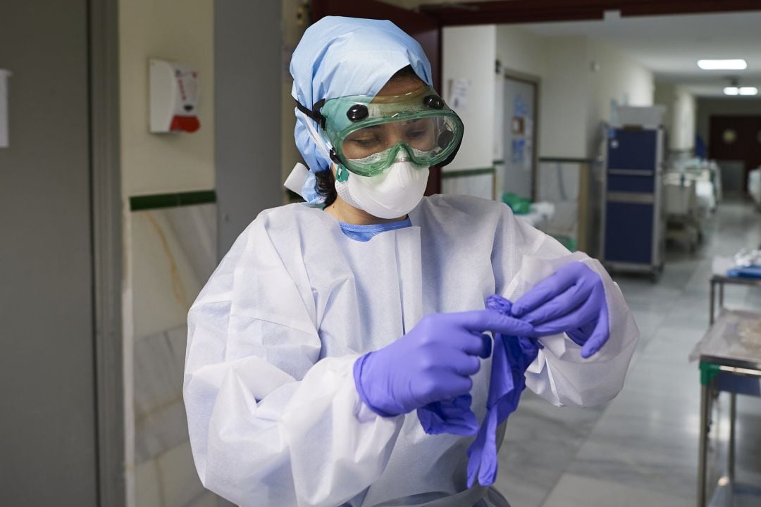 Enfermera preprarándose con su equipo de protección