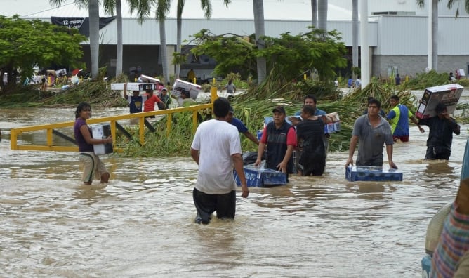 Varios vecinos de Acapulco se recuperan tras las inundaciones que ha dejado el huracán &#039;Ingrid&#039; a su paso por México