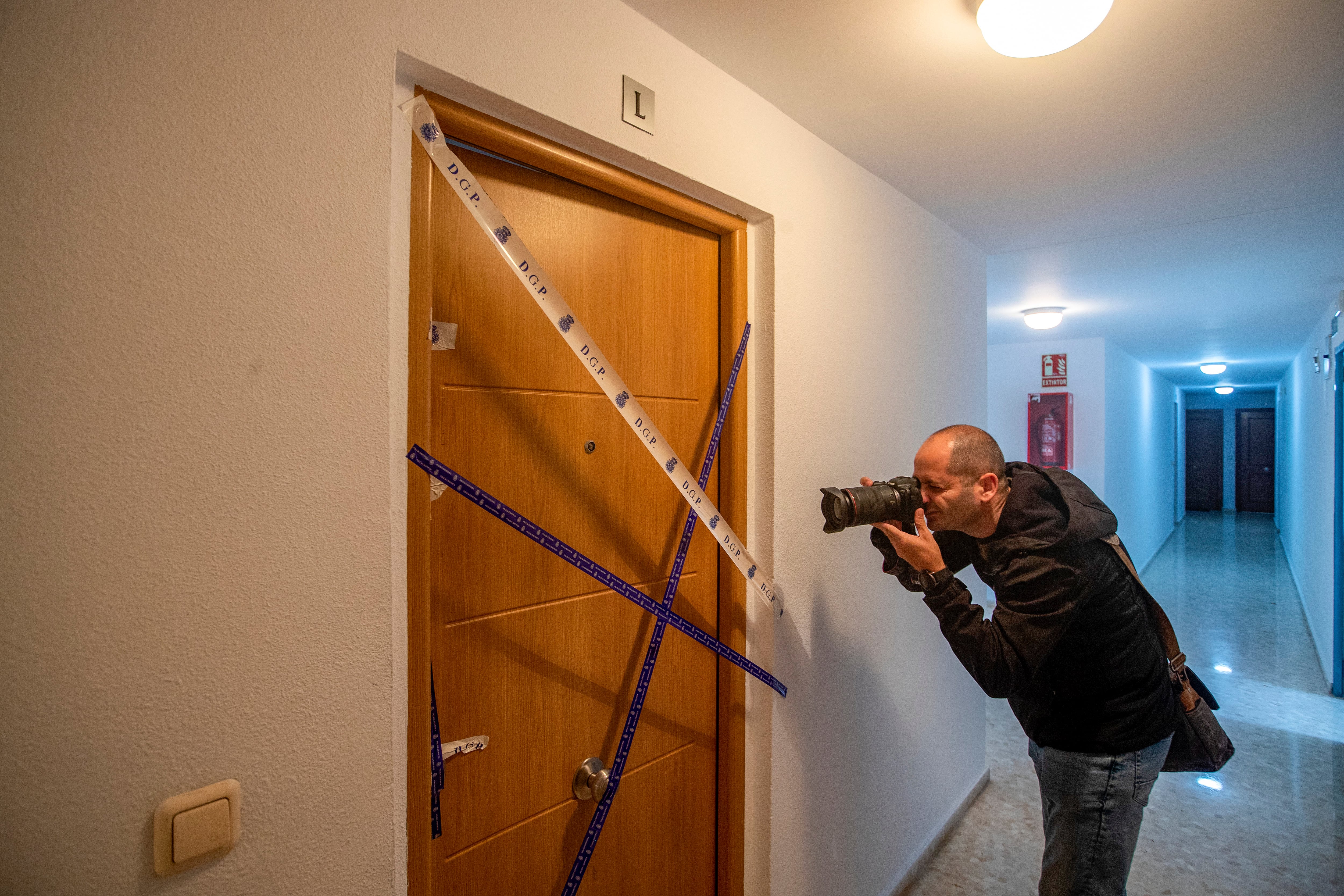 Un cámara fotografía el precinto policial en la entrada a la vivienda de El Puerto de Santa Maria (Cádiz) donde este domingo ha sido asesinada una mujer a manos de su pareja.