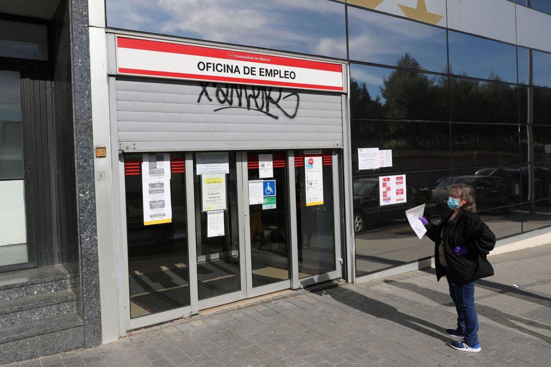Una mujer espera ante una oficina de empleo