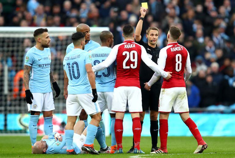 Aaron Ramsey es amonestado en un encuentro entre el Arsenal y el Manchester City.