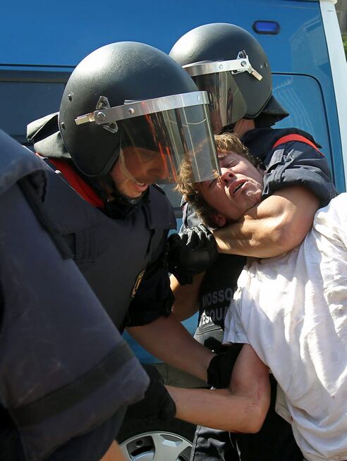 Dos policías autonómicos detienen a una persona en la calle Wellington esquina con la de Villena, donde al menos cuatro jóvenes han sido detenidos por los Mossos d&#039;Esquadra en un nuevo incidente entre la policía catalana y los jóvenes &#039;indignados&#039; que permanecen en los alrededores del parque de la Ciutadella, en donde esta mañana han intentado impedir la entrada de los diputados al Parlament