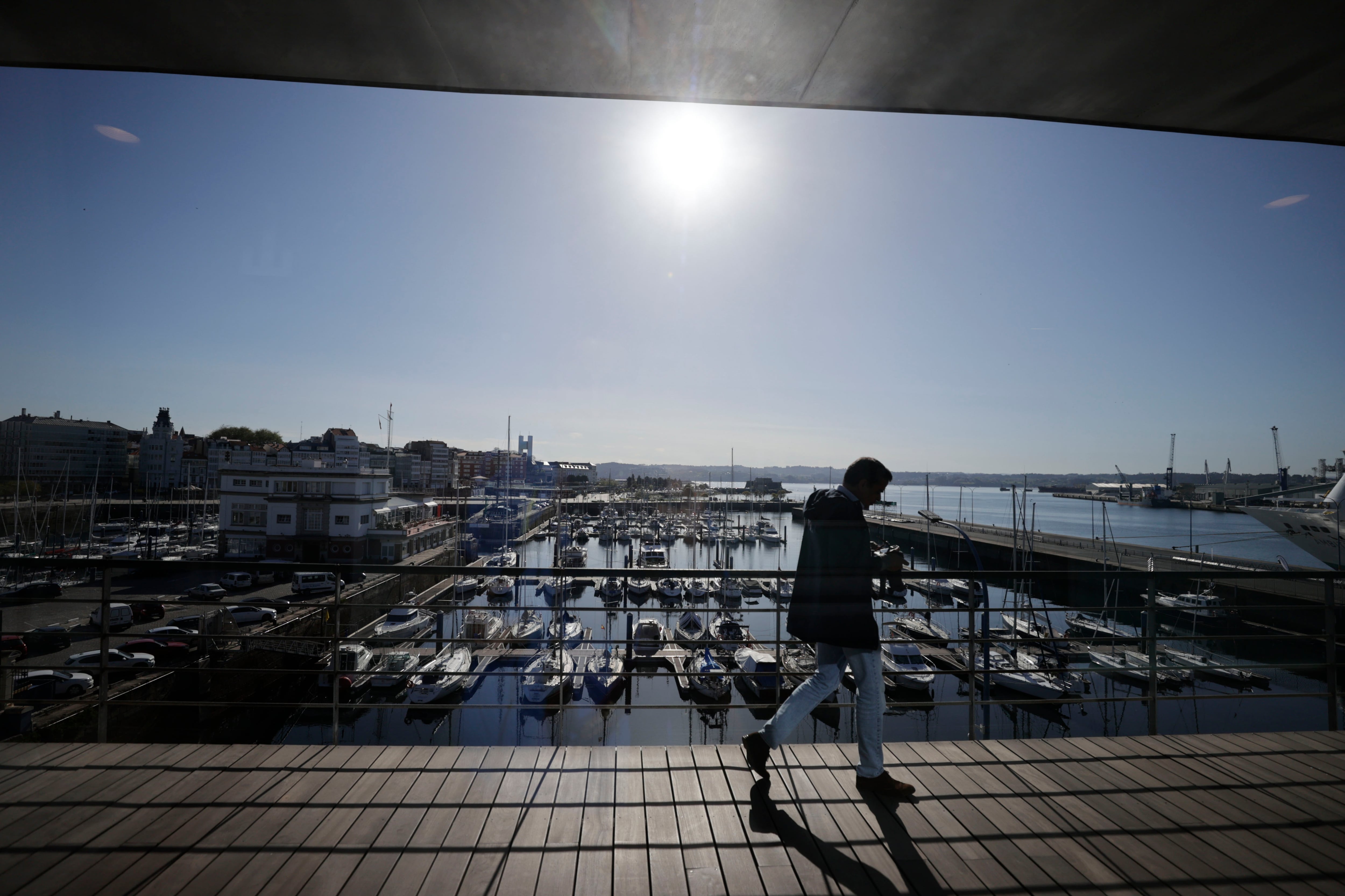 A CORUÑA, 23/04/24.- Un hombre caminaba este martes por el Palacio de Exposiciones y Congresos de A Coruña (Palexco), con el puerto al fondo, en una nueva jornada de cielos despejados aunque con notable descenso de las temperaturas. EFE/Cabalar
