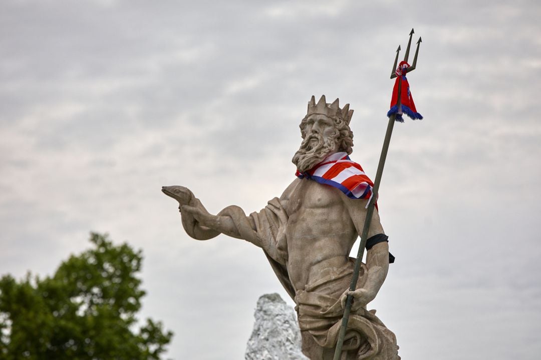 La estatua de la fuente de Neptuno, con una bufanda del Atlético de Madrid y un brazalete negro en el brazo en recuerdo del niño Saúl.