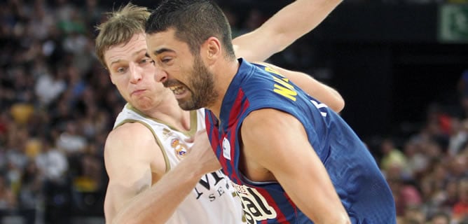 El escolta del Regal FC Barcelona, Juan Carlos Navarro (d), supera la defensa del lituano Martynas Pocius, del Real Madrid, durante la segunda semifinal de la Supercopa Endesa