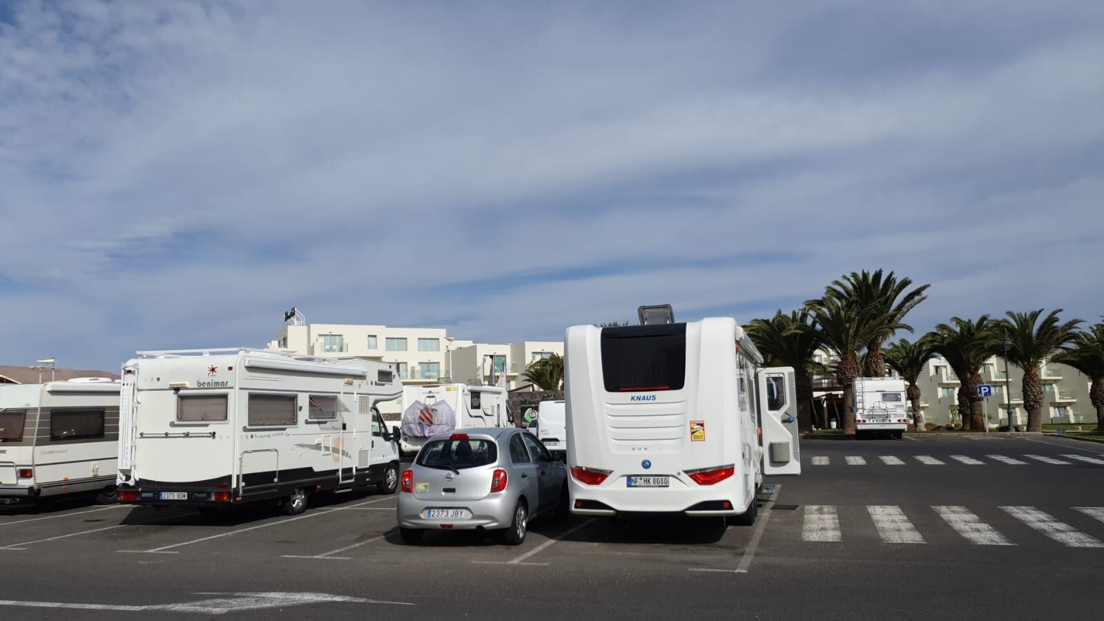 Autocaravanas estacionadas en el aparcamiento de la &#039;playa de Los Charcos&#039;.