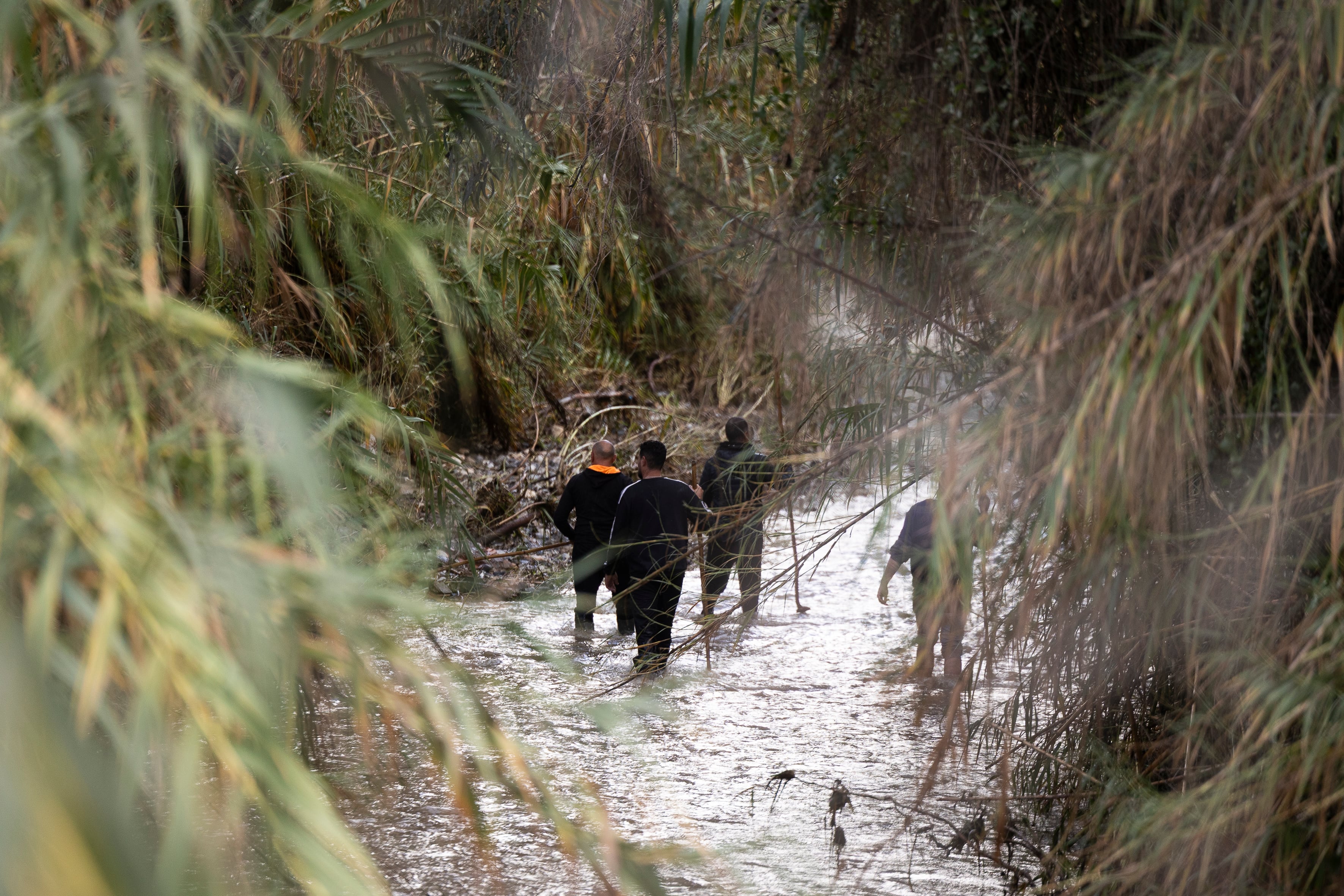 Un grupo de voluntarios en el río Fahala a su paso por Alhaurín el Grande (Málaga) en el dispositivo de búsqueda junto a la Guardia Civil de los dos hombres desaparecidos después de que la corriente arrastrara su furgoneta anoche durante el temporal. EFE / Carlos Díaz.