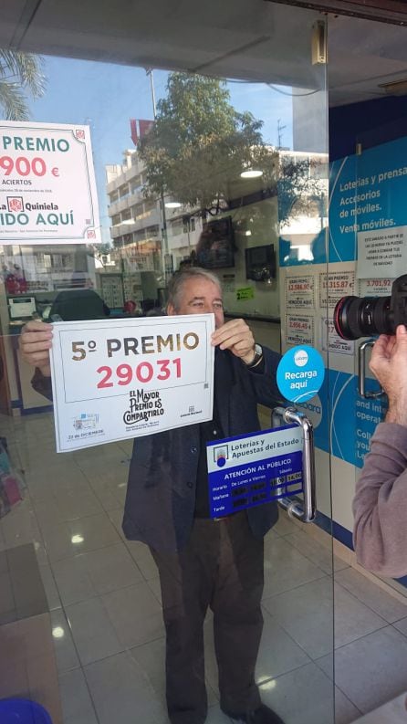 El responsable de la adminsitración colocando el cartel del premio