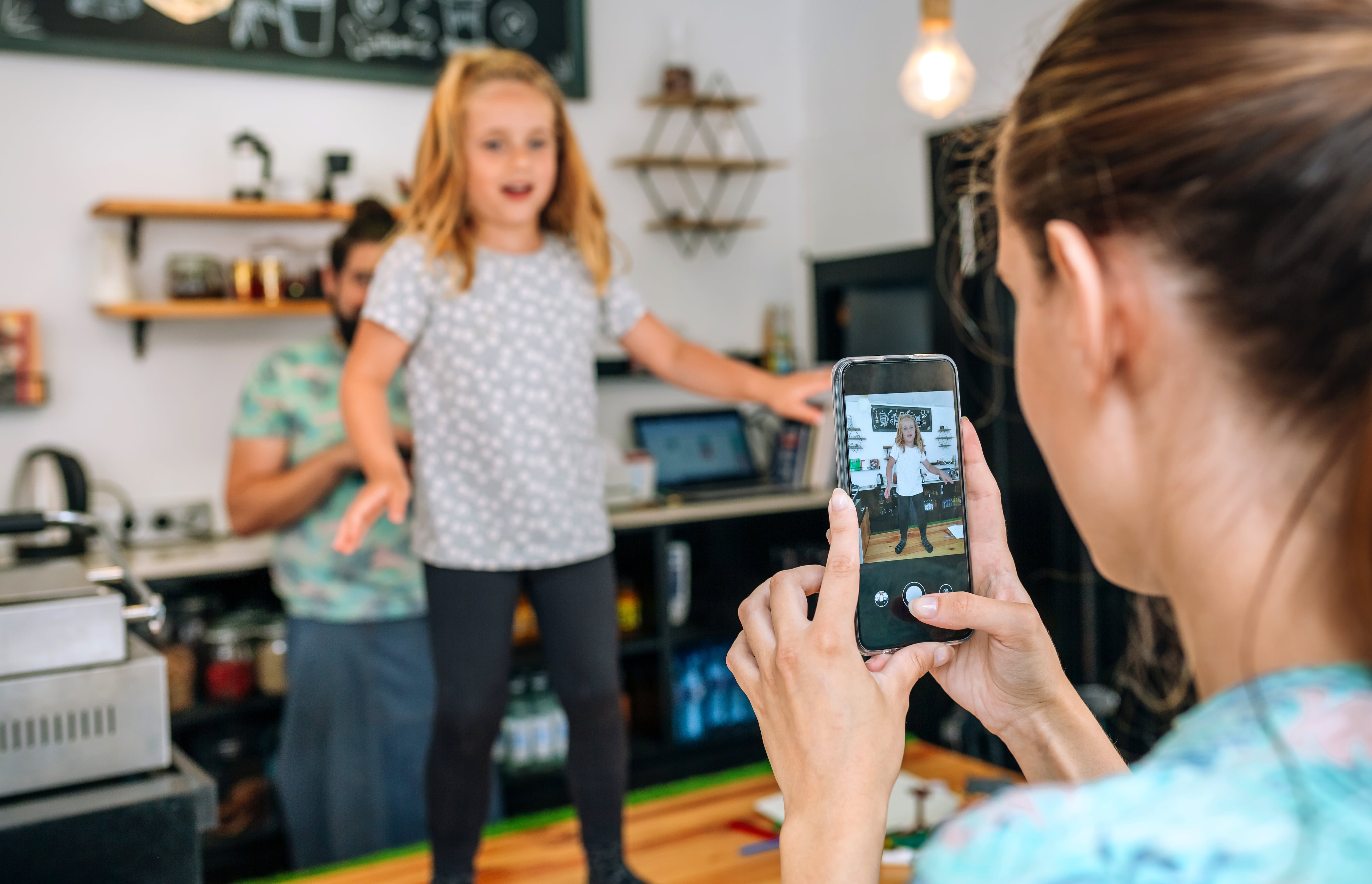 Madre realizando una foto de su hija con el móvil.