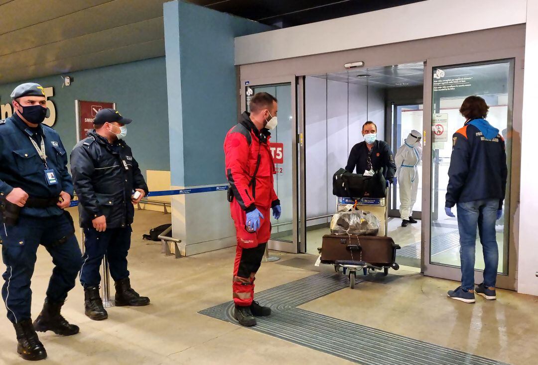 Viajeros llegando del vuelo de India al aeropuerto de Fiumicino en Italia