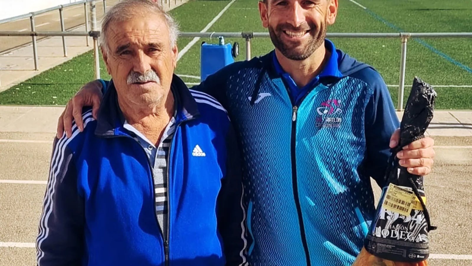 Manuel Díaz con su hijo Juan que porta un jamón ganado por ayudar al club.