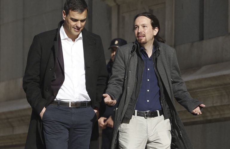 Los líderes del PSOE, Pedro Sánchez, y de Podemos, Pablo Iglesias, caminan juntos hacia la sala Martínez Noval del Congreso, donde se reúnen para explorar un posible pacto.