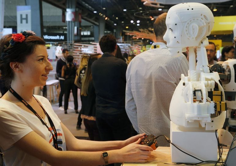 Una visitante maneja un robot humanoide en una Feria de Robótica celebrada en Europa. 