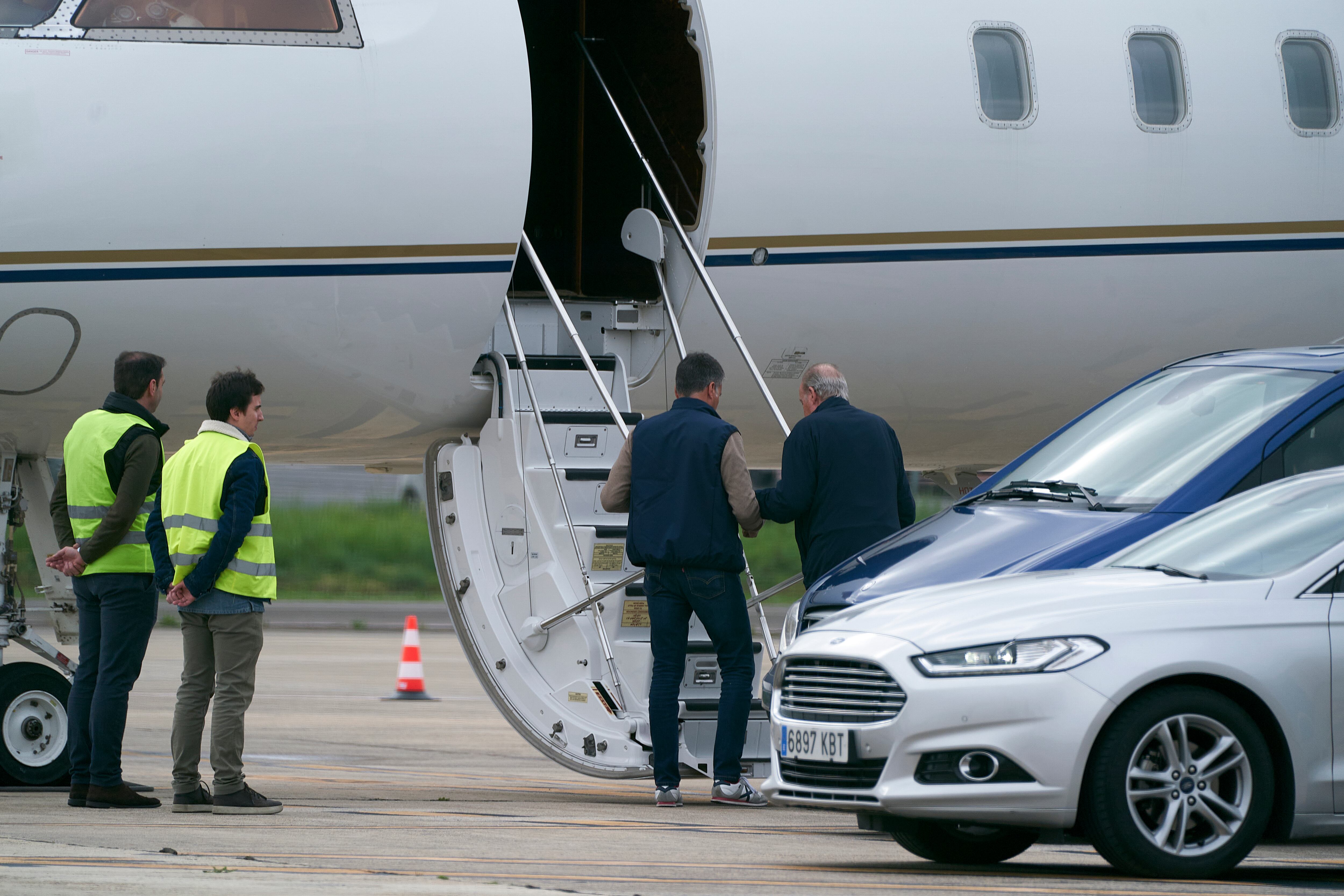 El rey emérito Juan Carlos I (d) coge el avión en el aeropuerto de Vitoria este martes tras haberse sometido a una revisión médica.