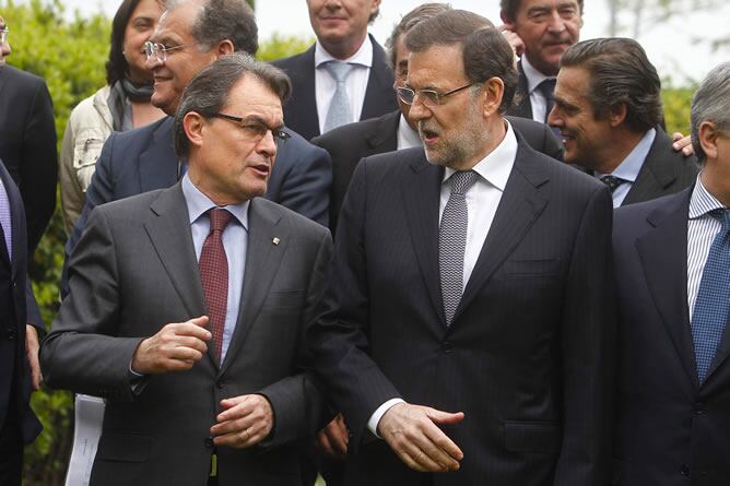 El presidente del Gobierno, Mariano Rajoy, y el presidente de la Generalitat de Cataluña, Artur Mas, conversan durante la foto de familia previa a la comida celebrada en Barcelona con empresarios del sector automovilístico .