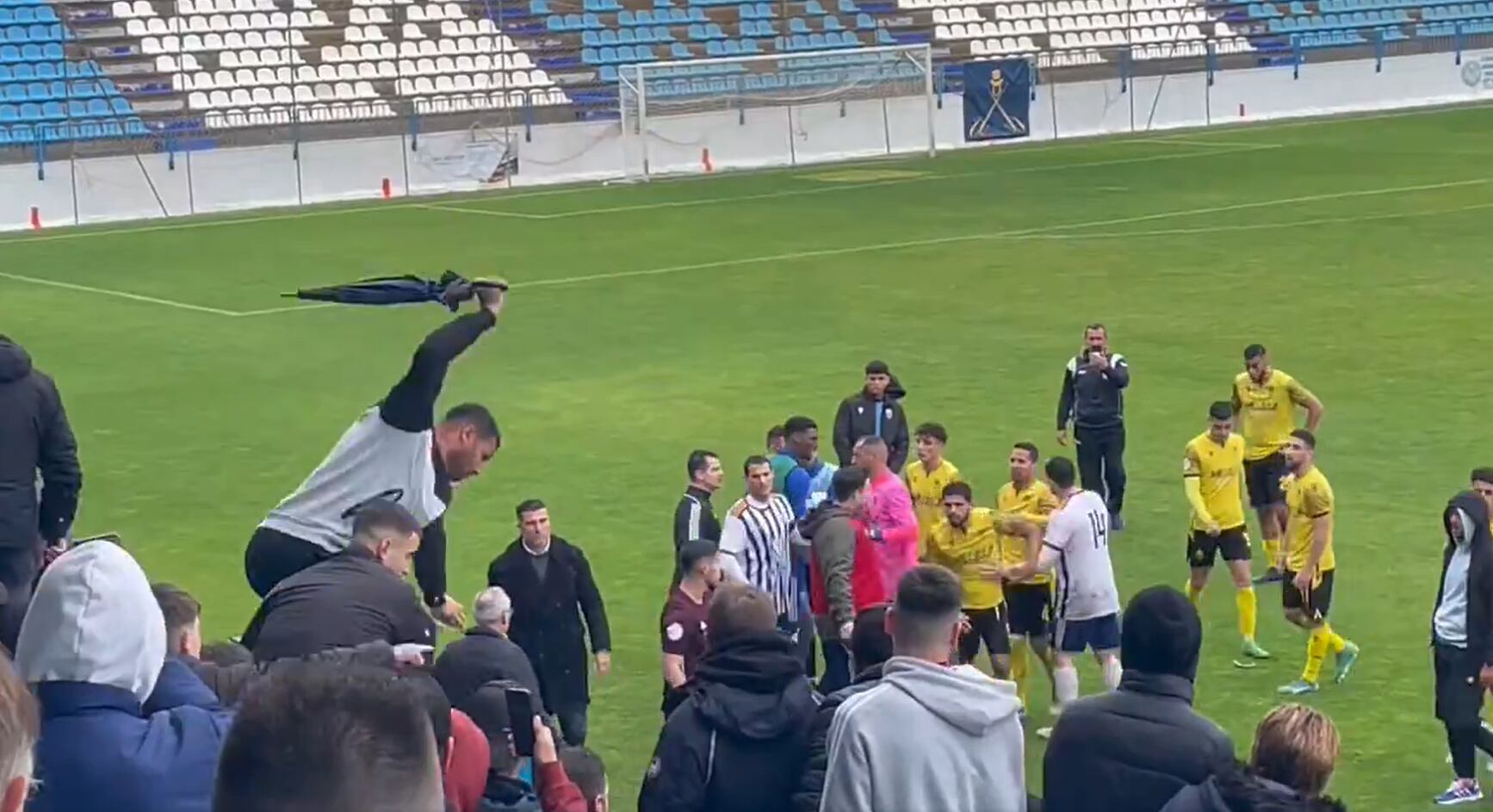 Un aficionado golpea con un paraguas durante el Motril-Atlético Melilla.