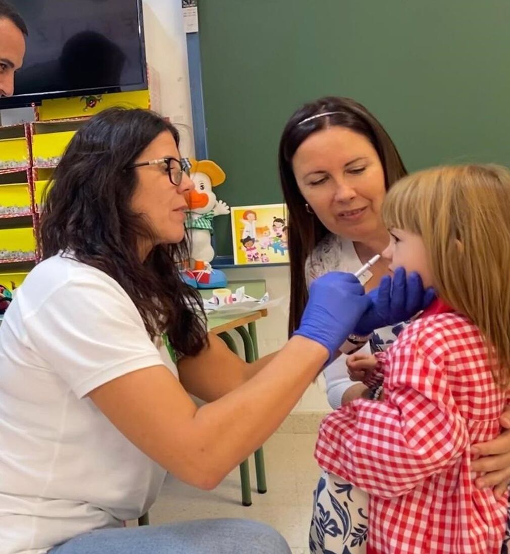 Archivo - Una niña recibe en su colegio la vacuna de la gripe por vía intranasal