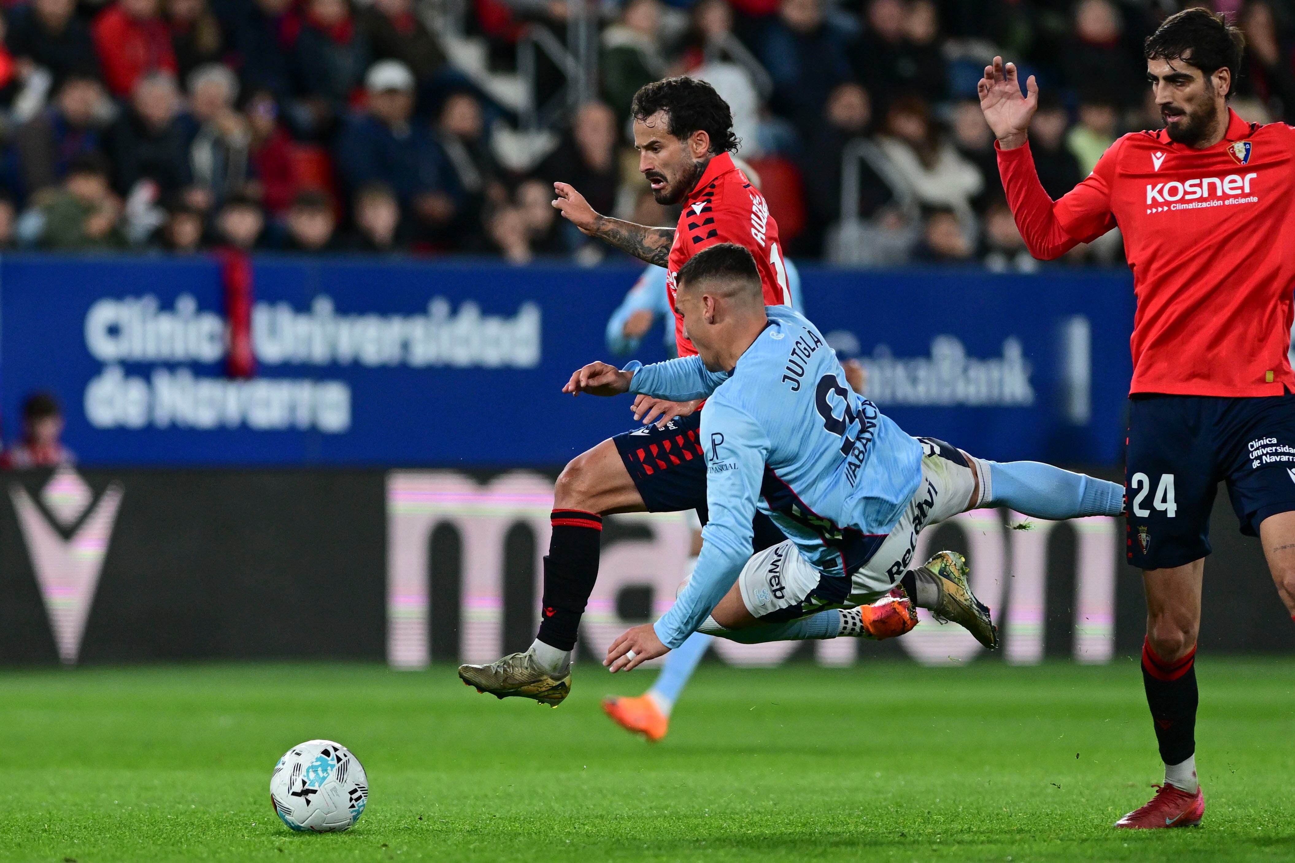 PAMPLONA, 26/10/2025.- El delantero del Celta Ferrán Jutglá (c) cae ante Rubén García (i), de Osasuna, durante el partido de LaLiga de fútbol que CA Osasuna y Celta de Vigo disputan este domingo en el estadio de El Sadar, en Pamplona. EFE/Iñaki Porto
