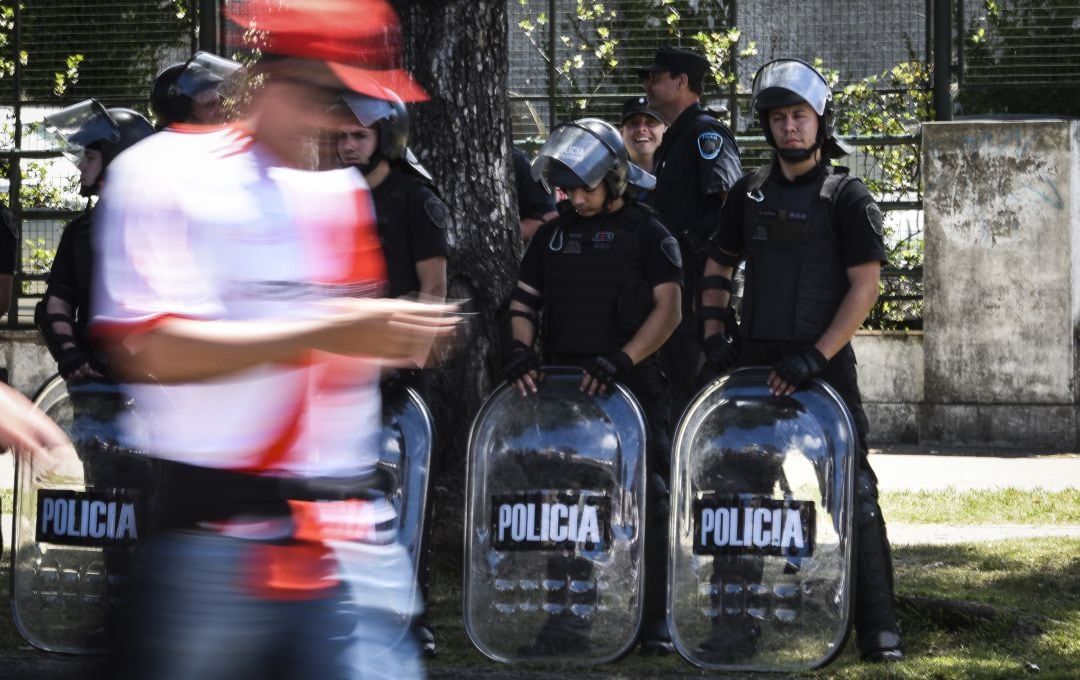 Un hincha de River pasa por delante de la policía antes de que se suspendiera el River - Boca del Monumental.