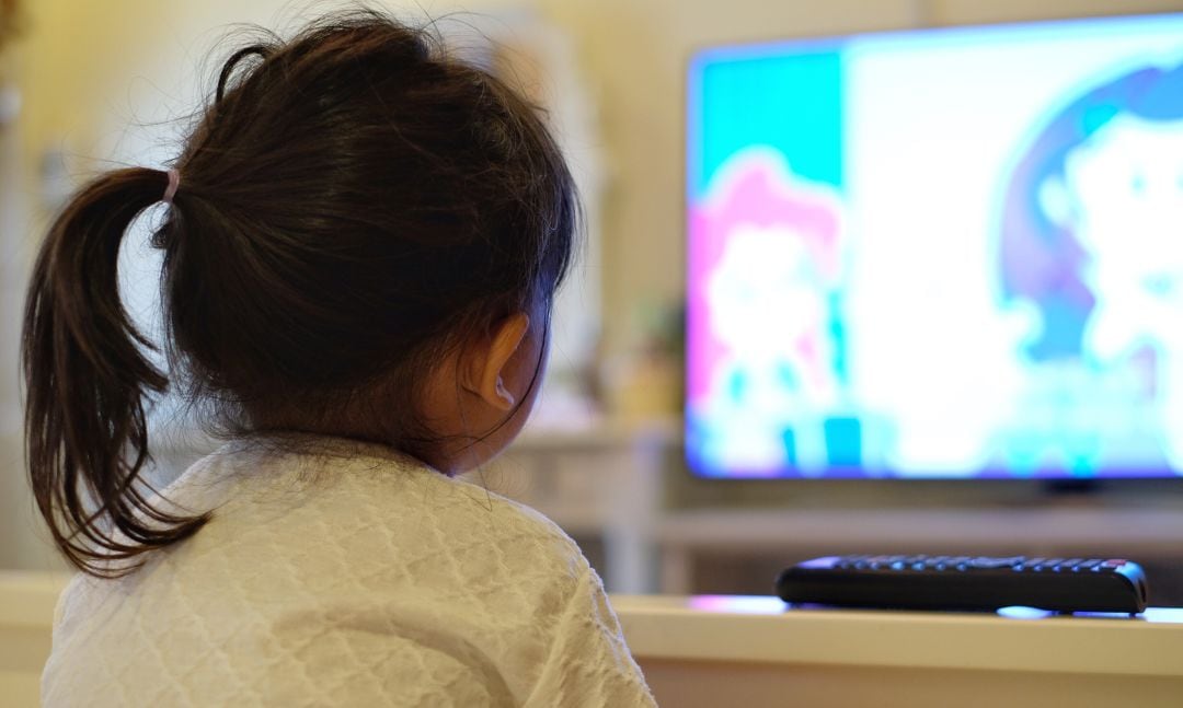 Una niña viendo la televisión.