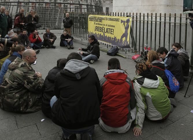 Un grupo de indignados, junto a la estatua de Carlos III en la Puerta del Sol