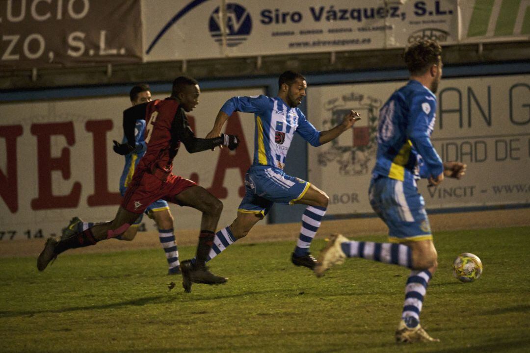 Joaqui conduce el balón ante la oposición de un jugador del Mirandés B en el último encuentro en El Montecillo.