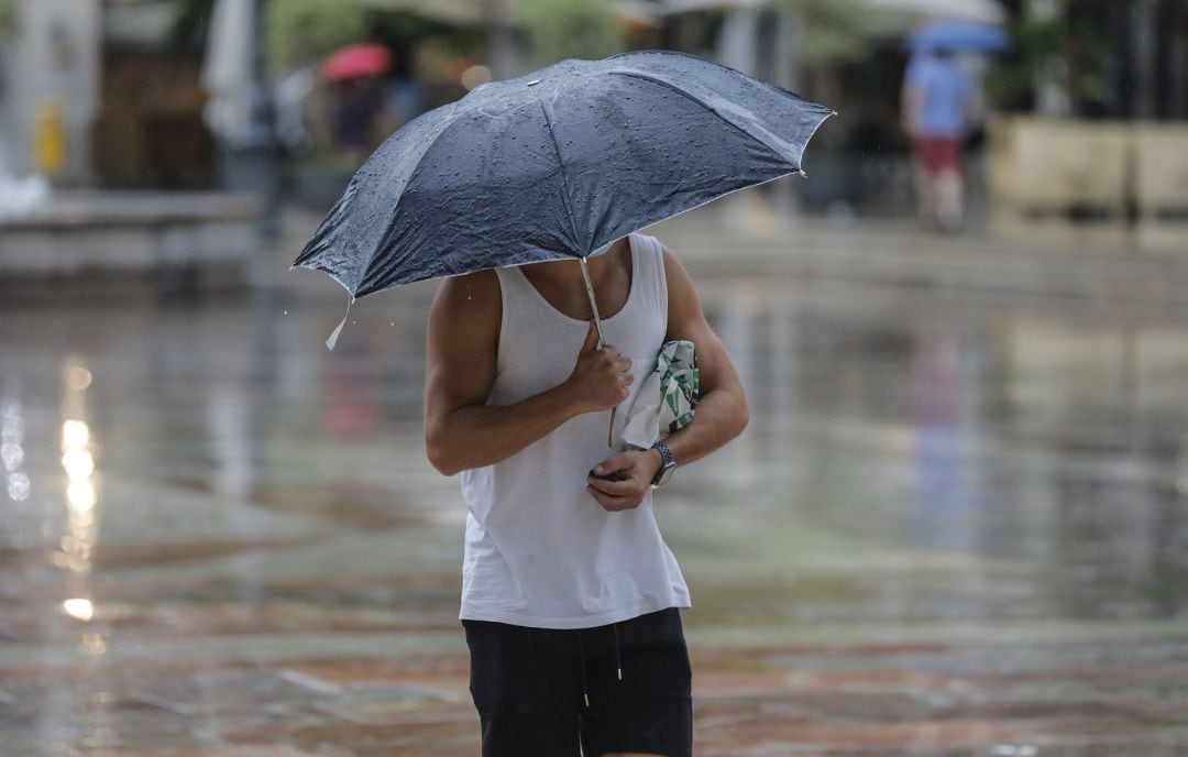 Una persona sostiene un paraguas mientras llueve en València.