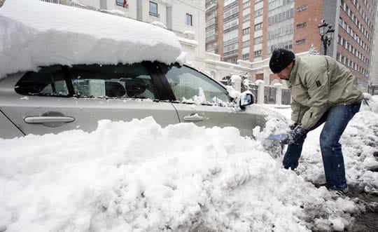 Un hombre retira la nieve de su coche en Burgos capital  (Reuters)