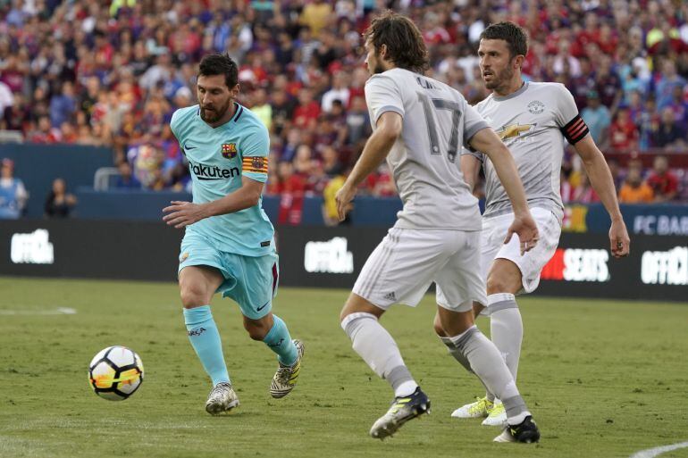 Messi dispuntando el balón con Daley Blind durante el Barcelona - Manchester United. 