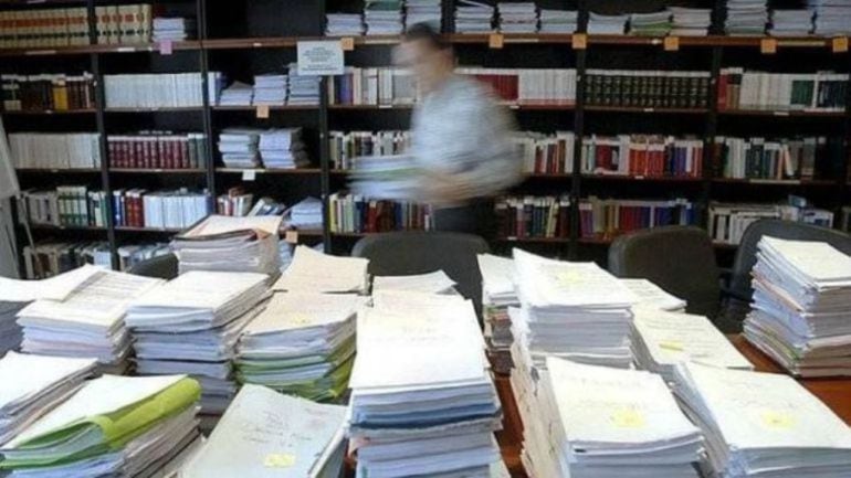 Documentos apilados en una sede administrativa 