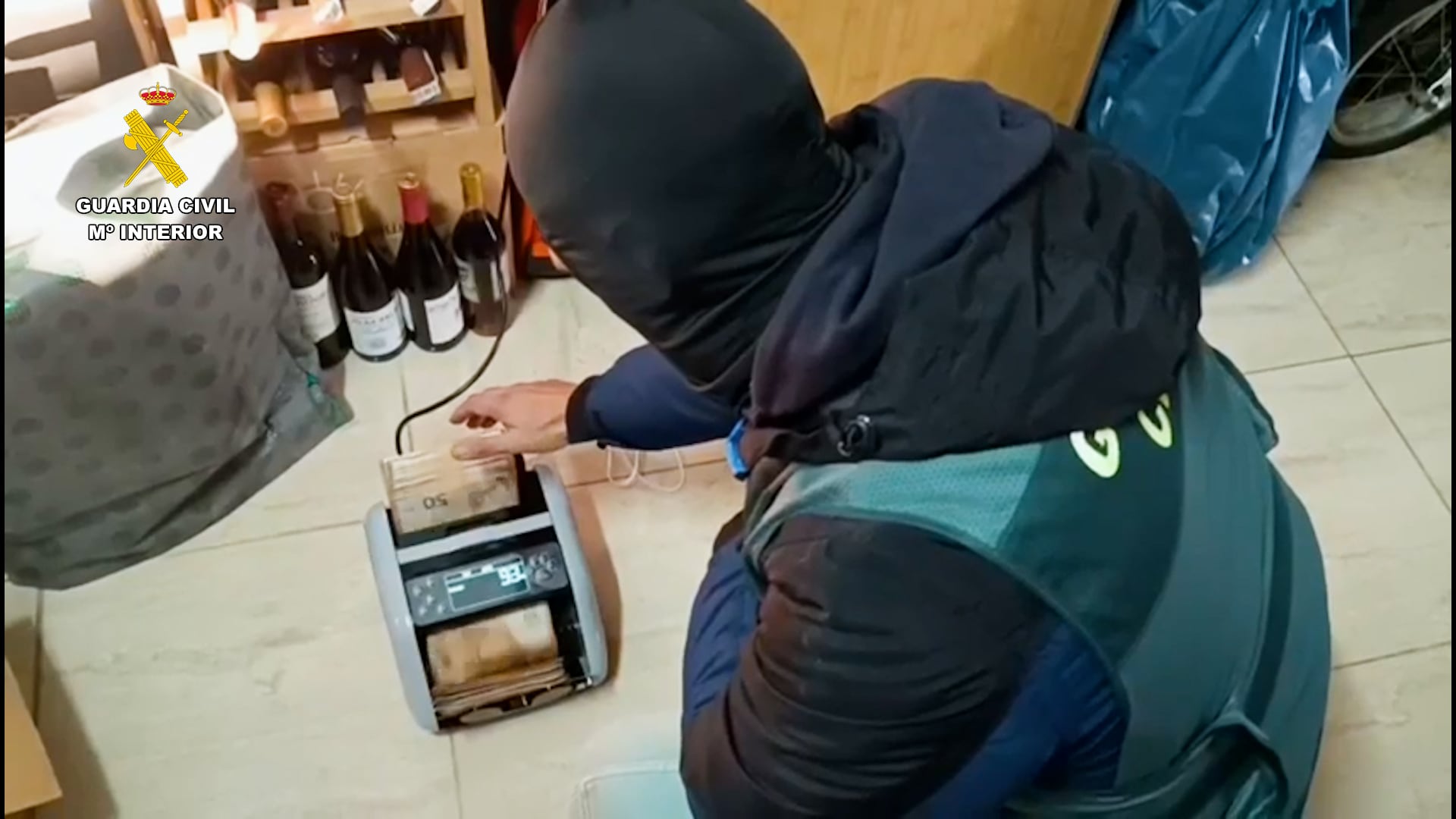 Agente de la guardia civil con una máquina de dinero