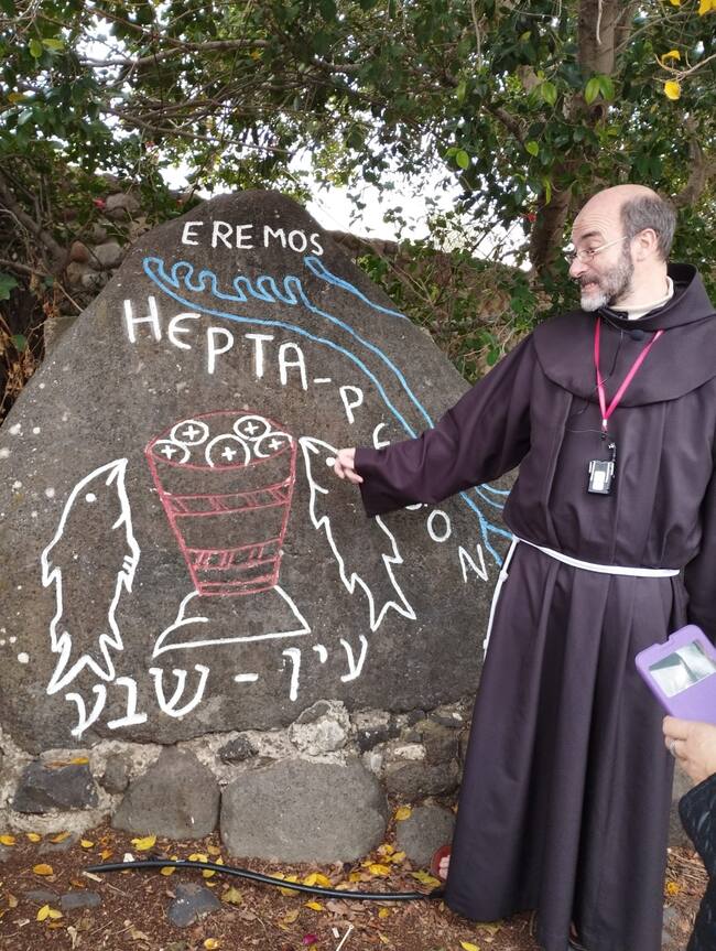 Fray Luis Quintana, junto a la piedra que simboliza el Milagro de la multiplicación de los panes y los peces