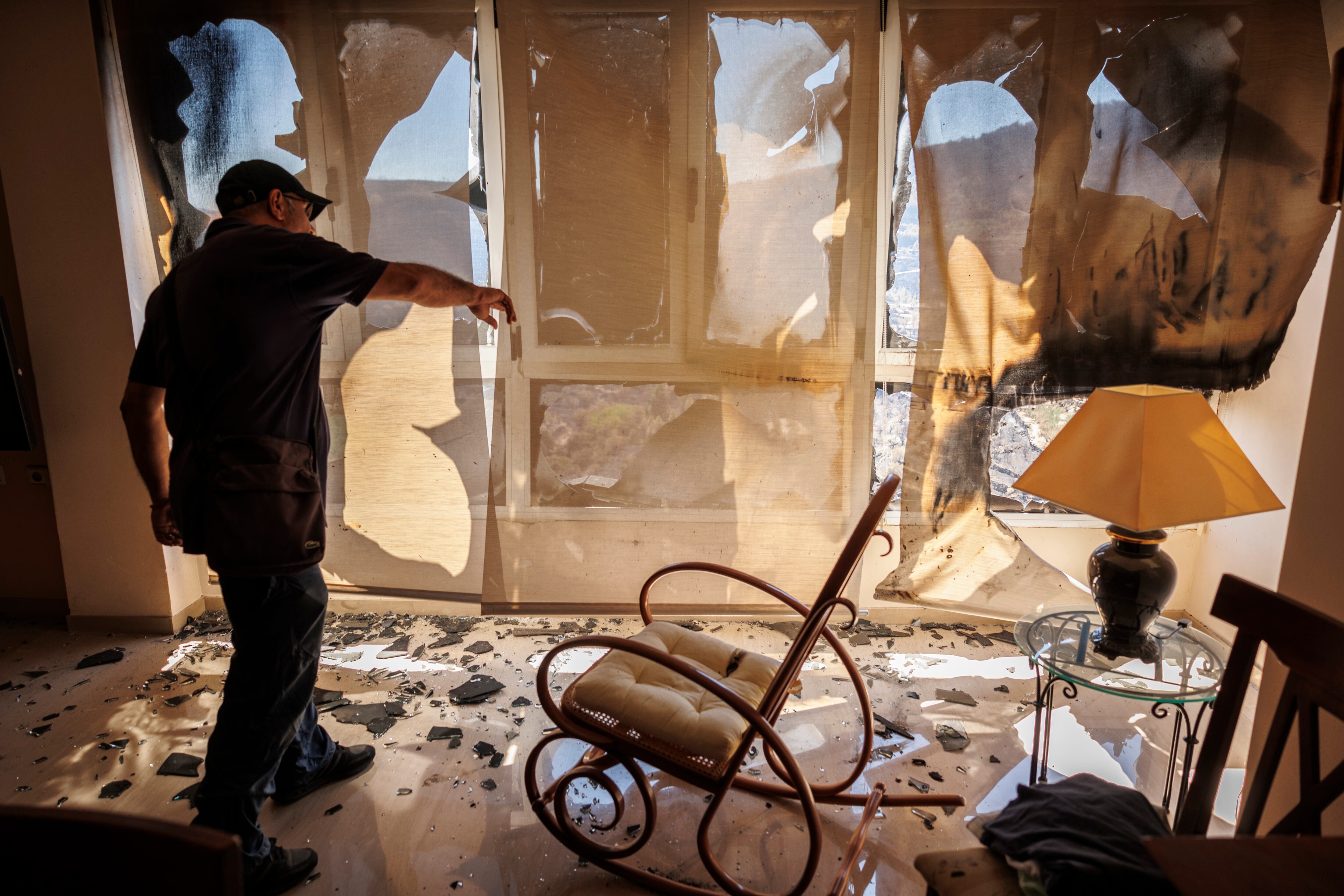 Un vecino del pueblo castellonense de Bejís comprueba el estado de su vivienda que ha sufrido desperfectos debido al incendio forestal