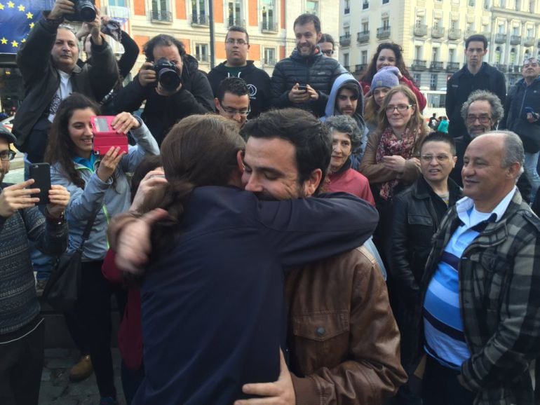 Pablo Iglesias y Alberto Garzón se abrazan en la Puerta del Sol de Madrid tars alzancar el preacuerdo electoral para el 26-J.