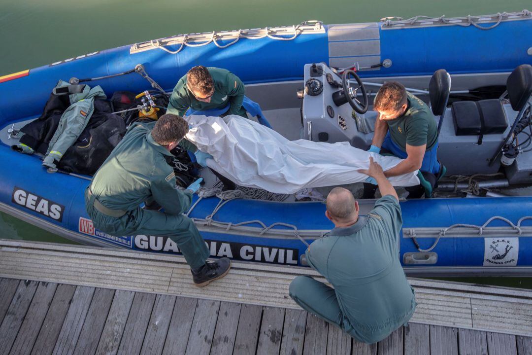 Fotografía facilitada por la Guardia Civil, de varios efectivos que trasladan a Barbate el cuerpo sin vida de un quinto inmigrante fallecido en el naufragio.