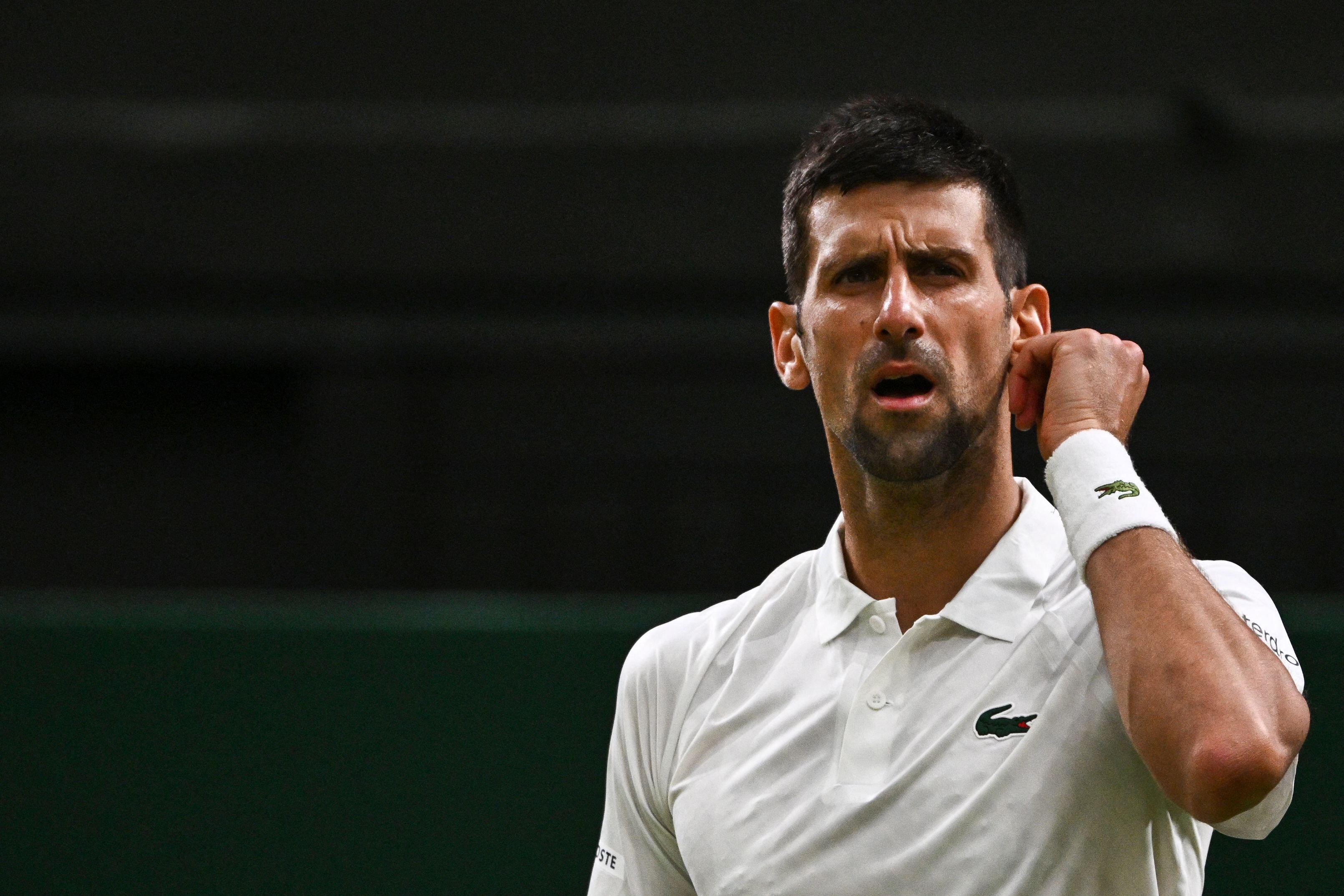 Serbia&#039;s Novak Djokovic reacts as he plays against Switzerland&#039;s Stan Wawrinka during their men&#039;s singles tennis match on the fifth day of the 2023 Wimbledon Championships at The All England Tennis Club in Wimbledon, southwest London, on July 7, 2023. (Photo by SEBASTIEN BOZON / AFP) / RESTRICTED TO EDITORIAL USE (Photo by SEBASTIEN BOZON/AFP via Getty Images)